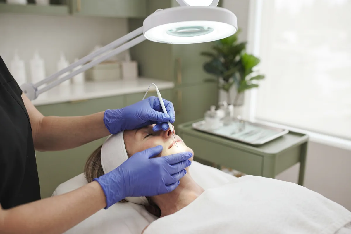 Electrologist wearing nitrile gloves treating chin follicles with a fine probe in Irvine CA
